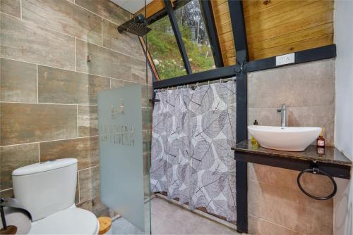 a bathroom with a toilet and a sink at Glamping en El Retiro in El Retiro