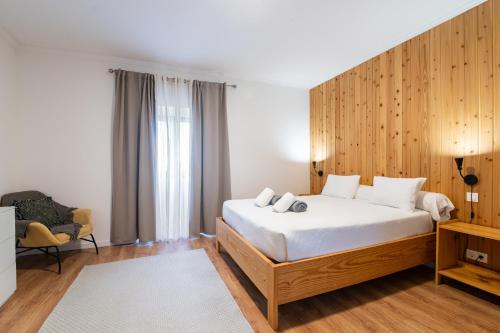 a bedroom with a bed with a wooden wall at Vila Rosario in Ponta Delgada