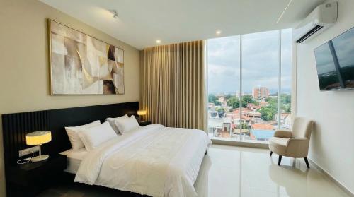 a bedroom with a bed and a large window at Hotel Murahno Collection in Cúcuta