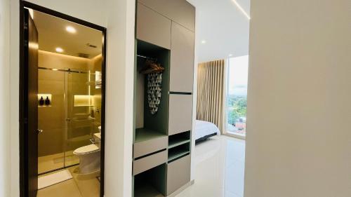 a bathroom with a shower and a toilet and a bed at Hotel Murahno Collection in Cúcuta