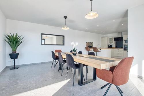 a dining room and kitchen with a wooden table and chairs at BELLEVUE 2, piscine, jacuzzi, sauna in Champcevinel