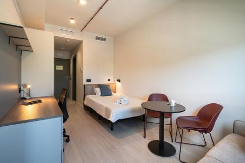 a hotel room with a bed and a table at Codomo Living Granada in Granada