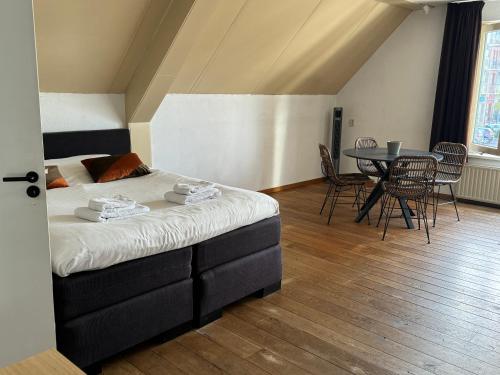 a bedroom with a bed and a table and chairs at Hotel BEAU in Bergeijk