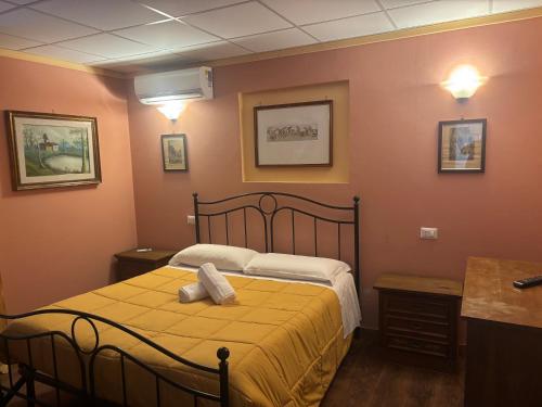 a bedroom with a bed with a yellow blanket at Locanda del Principe in Soriano nel Cimino