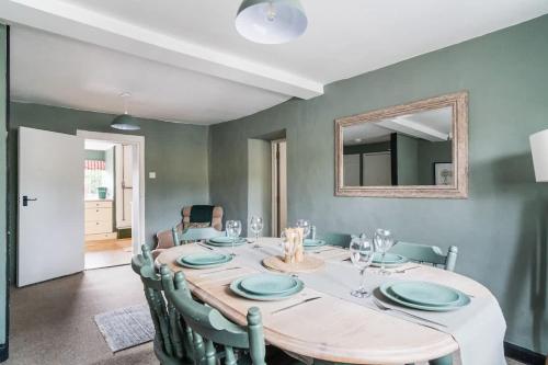 a dining room with a table with chairs and a mirror at Redesdale View, High Street with Private Garden in Moreton in Marsh