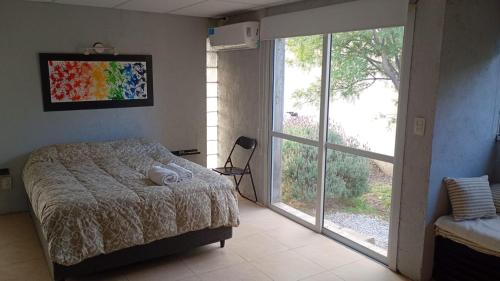 a bedroom with a bed and a large window at Uritorco Flats in Capilla del Monte