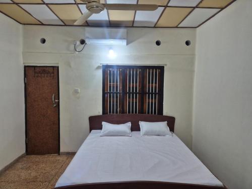a bedroom with a bed with two pillows on it at Naturehouse in Jaffna