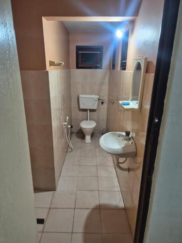 a bathroom with a toilet and a sink at Naturehouse in Jaffna