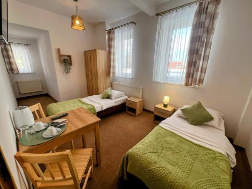 a room with two beds and a table and chairs at DW Bukówka in Karpacz