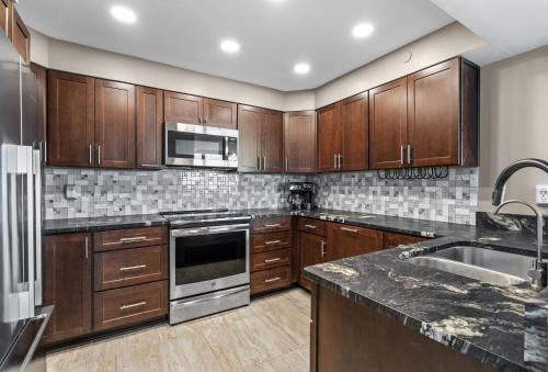 a kitchen with wooden cabinets and stainless steel appliances at Tristan Towers Unit 10E in Pensacola Beach