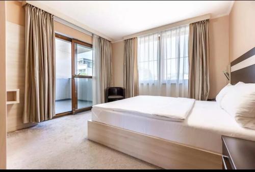 a bedroom with a large bed and a large window at Teplice Plaza in Teplice