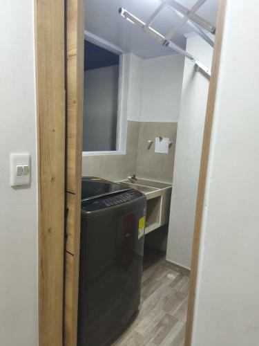 a small bathroom with a sink and a trash can at Apartahotel y casa de campo AMARU in San Gil