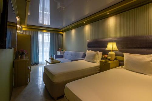 a hotel room with two beds and a couch at Hotel Craiova Olimp by Phoenicia in Olimp