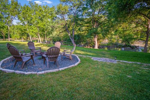 three chairs and a table in a park at Stone River Cabin in Canyon Lake