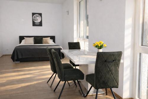 a dining room with a table and chairs and a bed at Stadthotel Carinthia in Klagenfurt