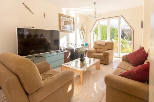 a living room with two couches and a tv at Guest H4U Villa Garden & Pool in Póvoa de Varzim