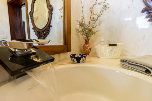 a bathroom with a white tub and a mirror at Guest H4U Villa Garden & Pool in Póvoa de Varzim