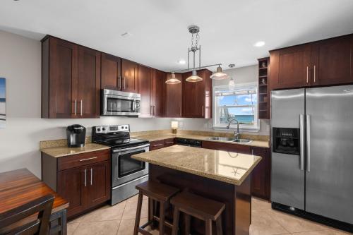 a kitchen with wooden cabinets and stainless steel appliances at Boardwalk Unit A18 in Pensacola Beach
