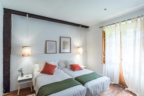 a bedroom with a large bed with red and green pillows at La Villa de Carla in Borleña