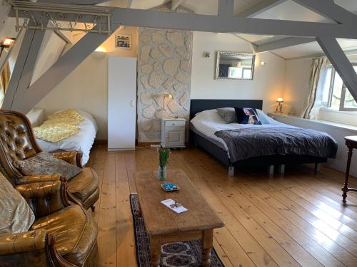 a living room with a bed and a couch at B&B Petit Chateau - Rust en Charme Nabij Gent, Brugge en de Zeeuwse kust in Biervliet