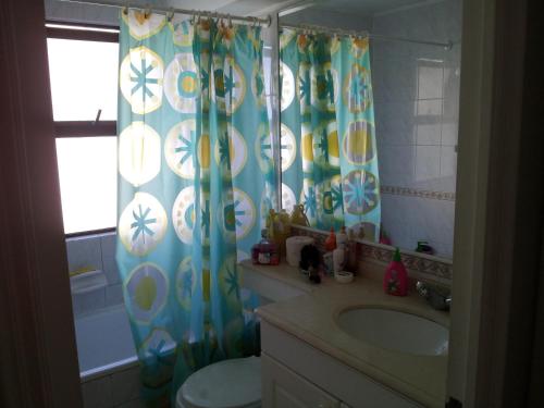 baño con lavabo y cortina de ducha en Departamento Playa Amarilla Con Con, en Concón