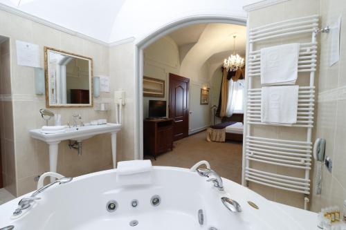 a large bathroom with a tub and a sink at Hotel Leopold I in Novi Sad