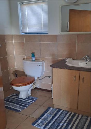 a bathroom with a toilet and a sink at Outeniqua Strandwoonstel in Great Brak River