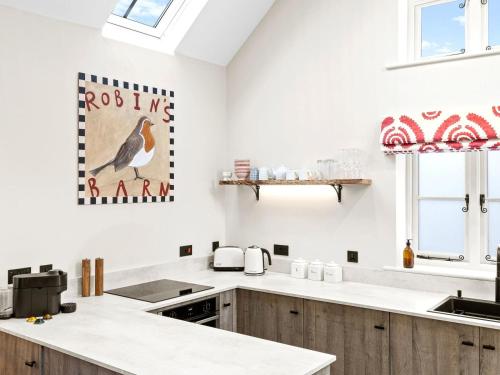 a kitchen with white countertops and a bird picture on the wall at 1 Bed in Ludlow oc-92768 in Hopton Cangeford