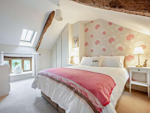 a bedroom with a large bed with a red blanket at 3 Bed in Wigton oc-92826 in Torpenhow