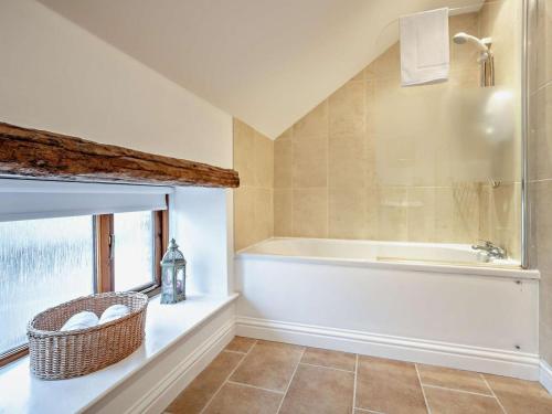 a bathroom with a bath tub and a window at 3 Bed in Wigton oc-92826 in Torpenhow