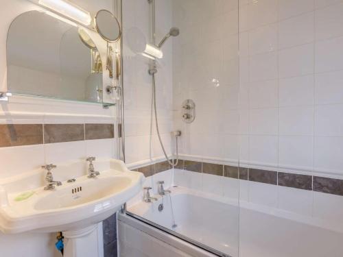 a white bathroom with a sink and a bath tub at 3 Bed in Bideford oc-57804 in Appledore