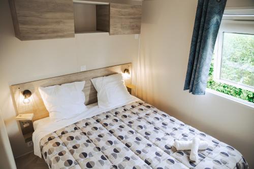 a bedroom with a bed in a room with a window at Camping Erreka in Bidart