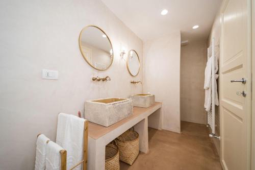 a bathroom with a sink and two mirrors on the wall at B&B MATINE' Suits & Rooms in Matino