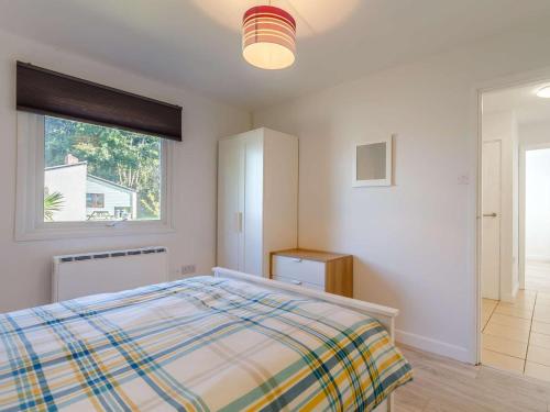 a white bedroom with a bed and a window at 2 Bed in Saltash oc-88309 in Wotter