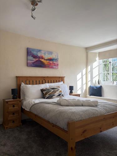 a bedroom with a large wooden bed and a window at The Cleave Inn in Lustleigh