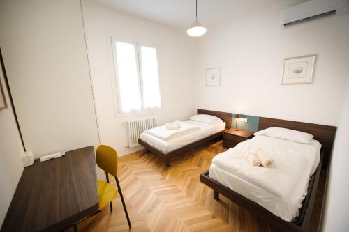 a bedroom with two beds and a desk and a table at Me amìa in Dolo