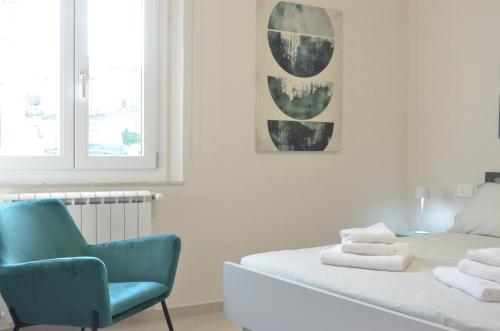 a bedroom with a bed and a blue chair at DomuS Miniato in San Miniato