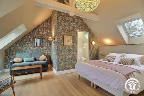 a bedroom with a large bed and a couch at Fontaine aman in La Roche-Jaudy