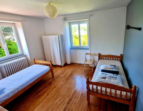a bedroom with two beds and two windows at Villa SURF Situation exceptionnelle à 3 min à pied de la plage de Pors Carn Pour 5 personnes Authentique Bien équipée Jardin & BBQ Parking privatif in Penmarch