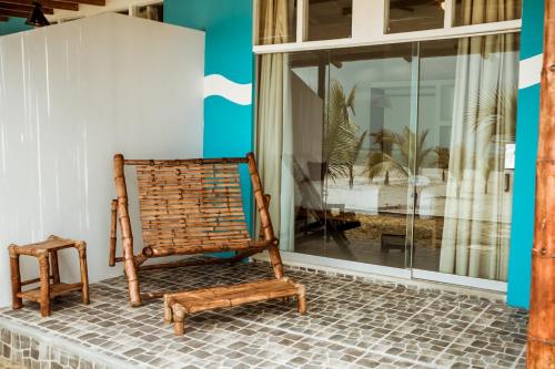 an old rocking chair sitting on the porch of a house at Nauti-k Beach Hotel in Tumbes