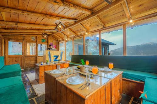 a dining room with a table and green chairs at Zostel Homes Khajjiar in Chamba