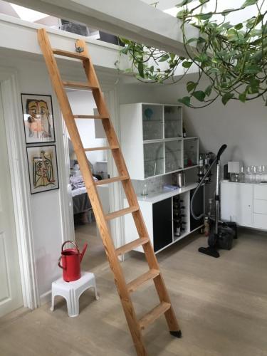 a wooden ladder with a red bucket on a stool in a room at Aarhus lejlighed med udsigt in Aarhus