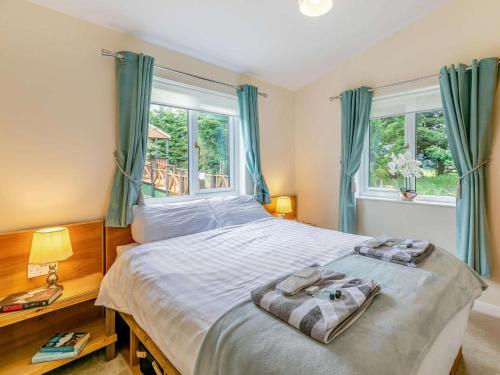 a bedroom with a large bed with blue curtains at 2 Bed in Malton oc-87936 in West Heslerton