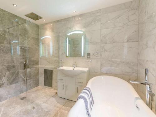 a bathroom with a tub and a sink and a shower at 2 Bed in Malton oc-87936 in West Heslerton