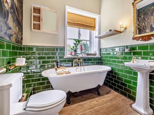 a green tiled bathroom with a tub and a toilet at 2 Bed in Hemel Hempstead oc-95536 in Great Gaddesden