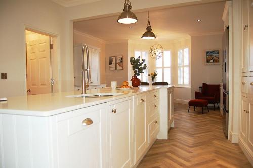 a kitchen with white cabinets and a kitchen island at Morwendon House with Sea View in Llanaber
