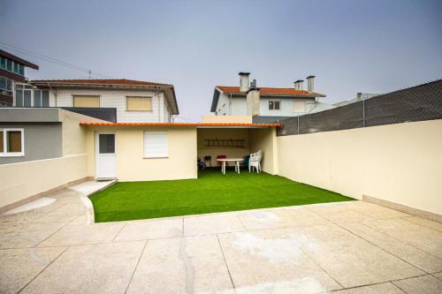 a backyard with a lawn in front of a house at Guest H4U - Garden & Beach Mindelo in Mindelo