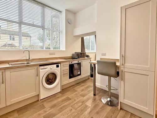 a kitchen with a washing machine and a sink at Modern new redeveloped studio Apartment in Clacton in Clacton-on-Sea