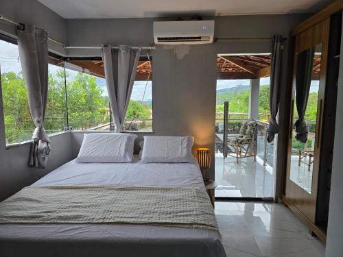 a bedroom with a bed and a balcony at Casa Parque do Ribeirão - Casa com piscina in Lençóis