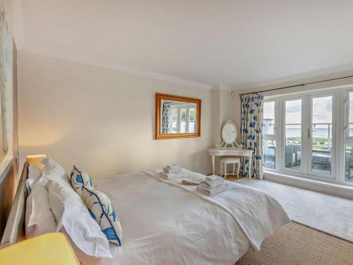 a bedroom with a large white bed and a window at 4 Bed in Bognor Regis oc-81446 in Bognor Regis